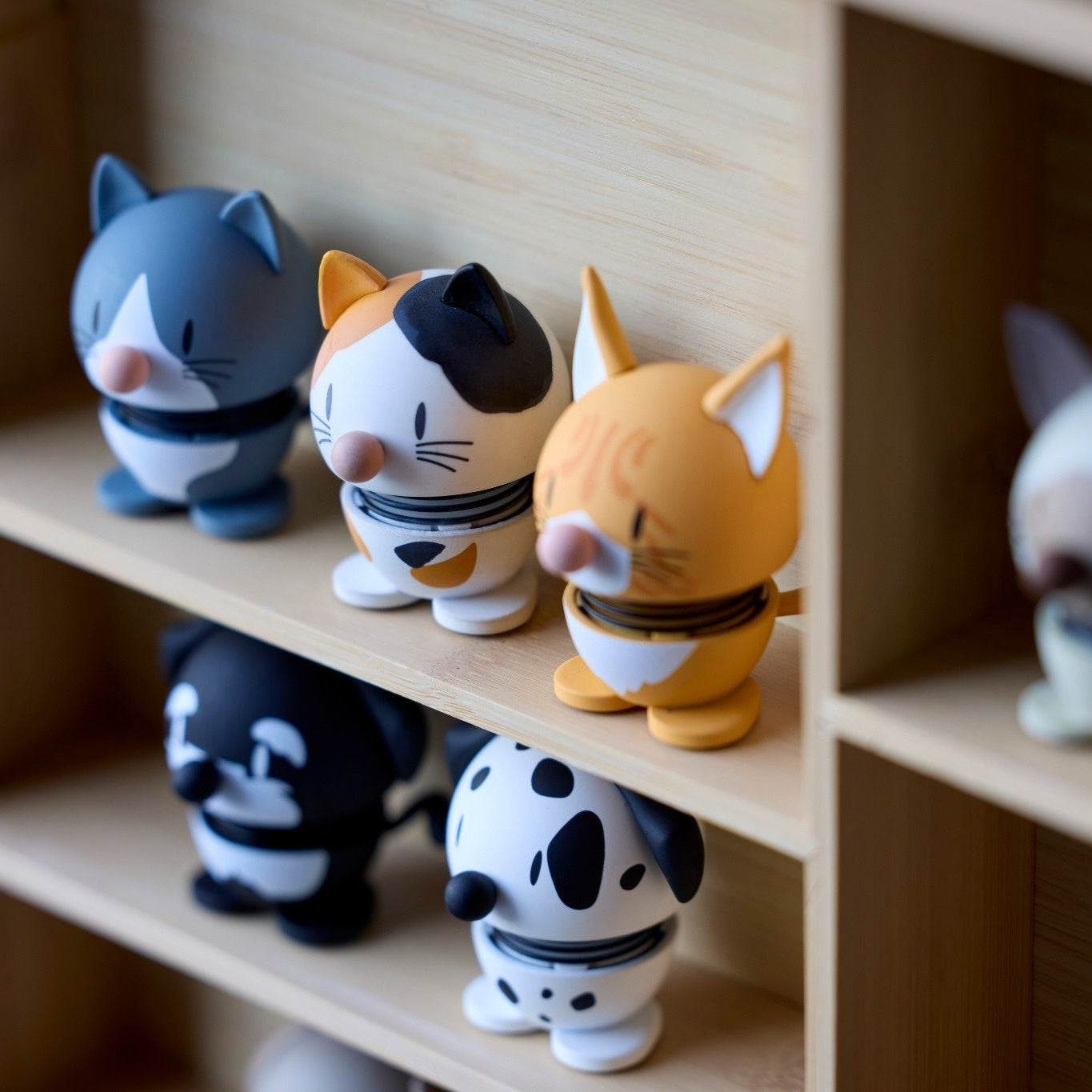 Collection of cat-themed figurines on a wooden shelf